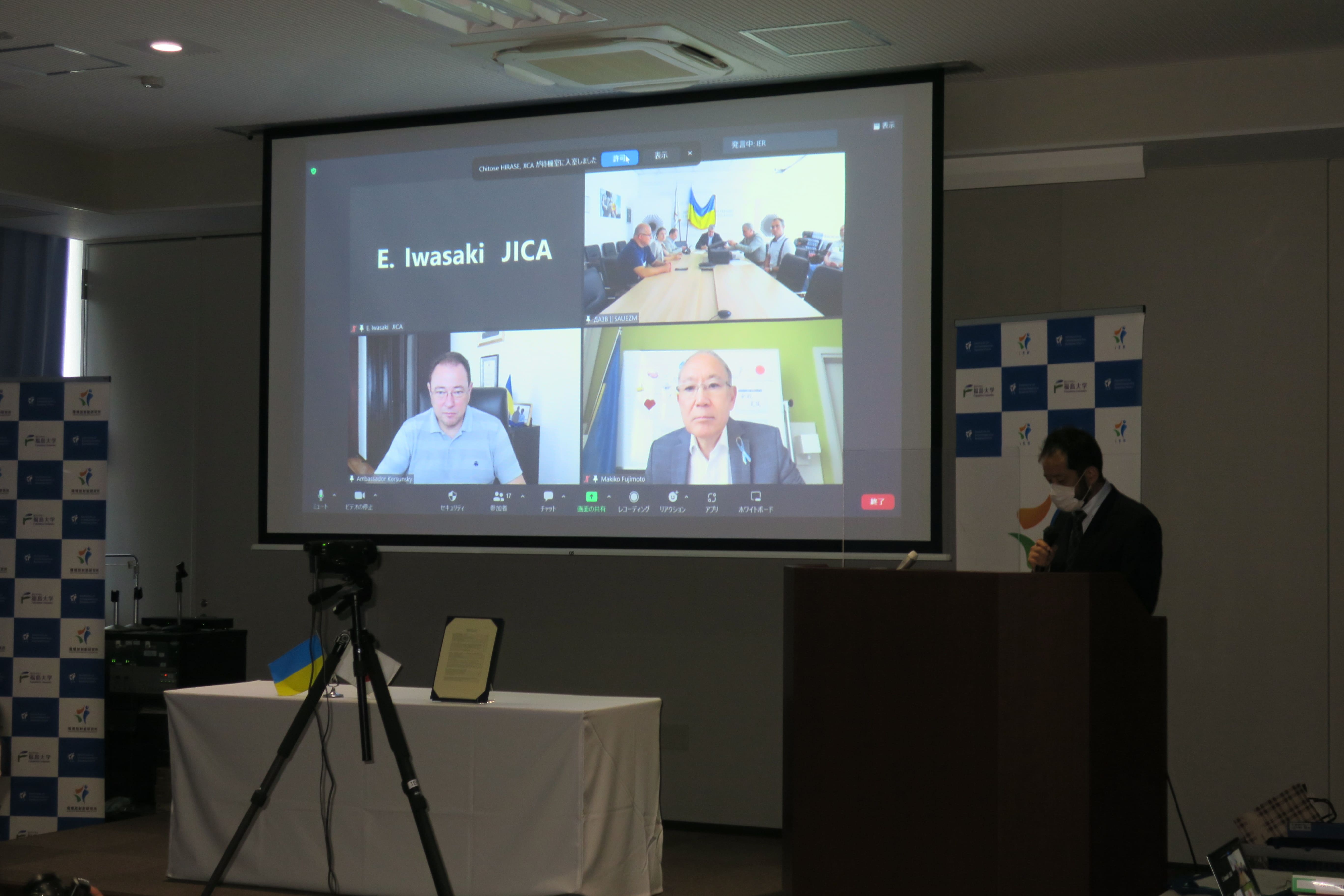 オンラインで行われた機材引渡式。スクリーン上右上がSAUEZM、エコセンターの関係者、左下がコルスンスキー大使、右下が松田大使