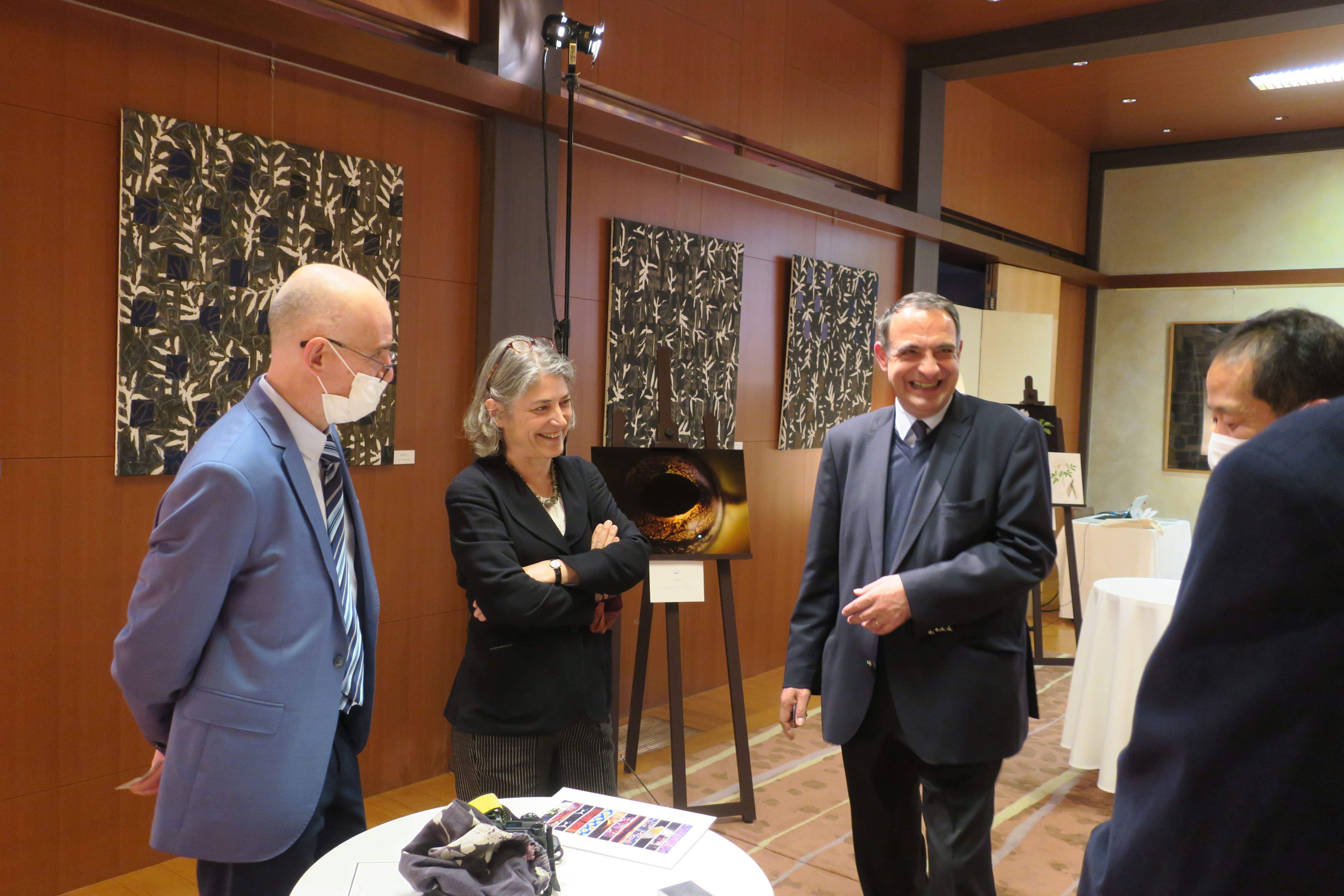 Director Nanba talking with the Ambassador and Embassy staff in front of Andre’s photo